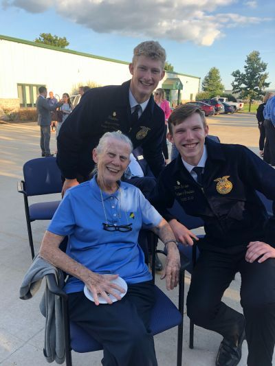 A woman in a wheelchair is posing for a picture with two young men.