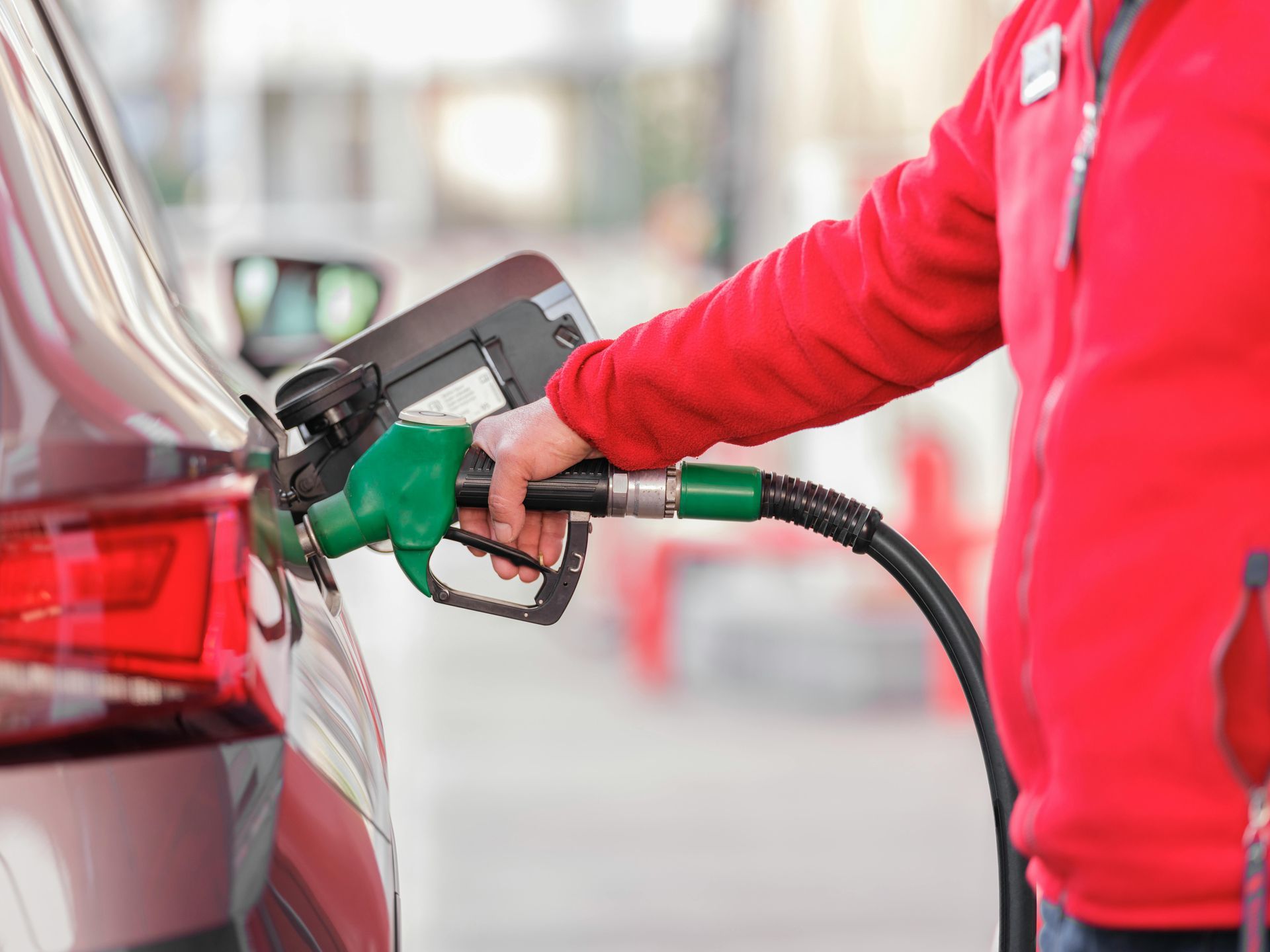 A person is pumping gas into a car at a gas station.