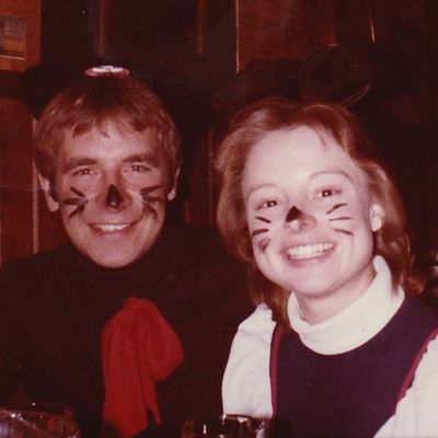 A man and a woman with cat face paint on their faces