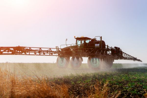 A tractor is spraying fertilizer on a field.
