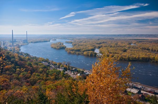 An aerial view of a river surrounded by trees and a city.