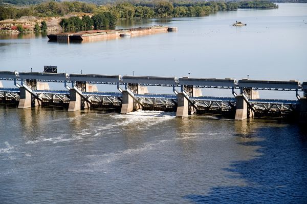 A bridge over a river with a barge in the background