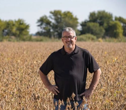 A man standing in a field with his hands on his hips