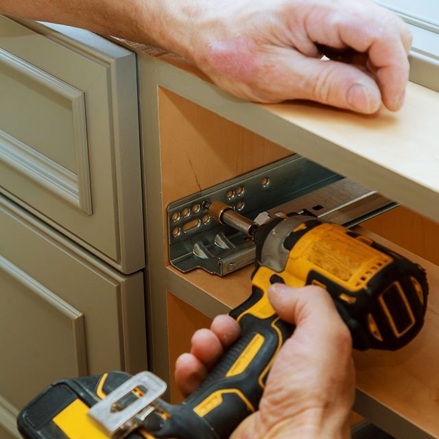 Unrecognized handyman adjusting cabinet door hinge. Unrecognized handyman adjusting cabinet door hinge.