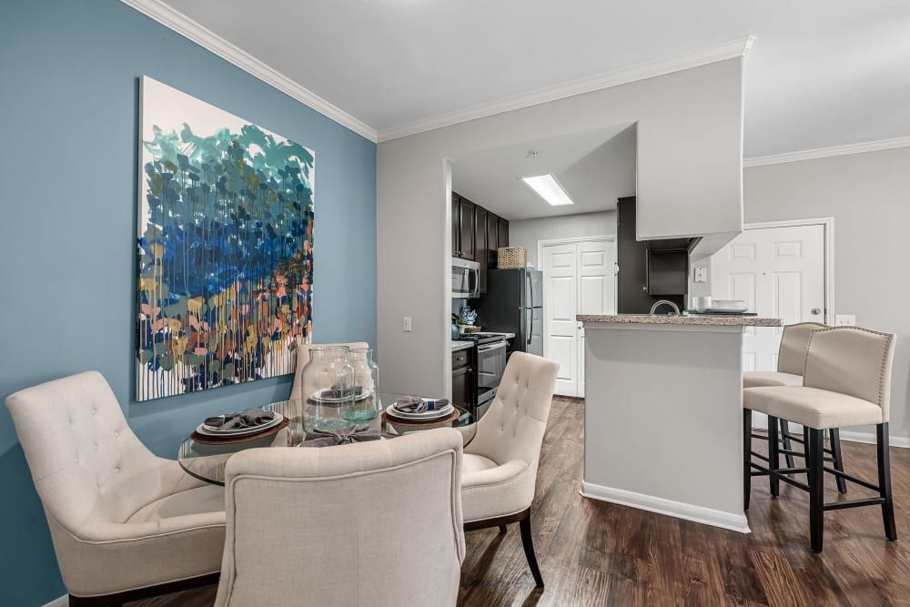 a dining room with a table and chairs and a painting on the wall at Marquis on Westheimer in Houston, TX.