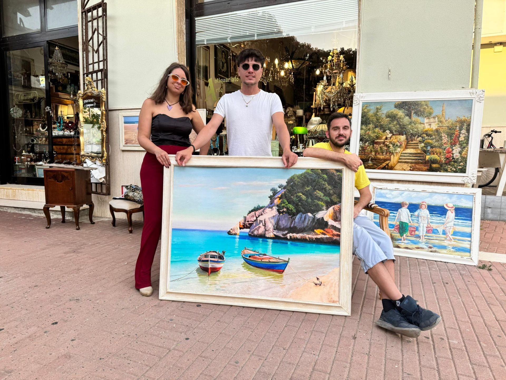 Un gruppo di persone in piedi una accanto all'altra che tengono in mano dei dipinti.