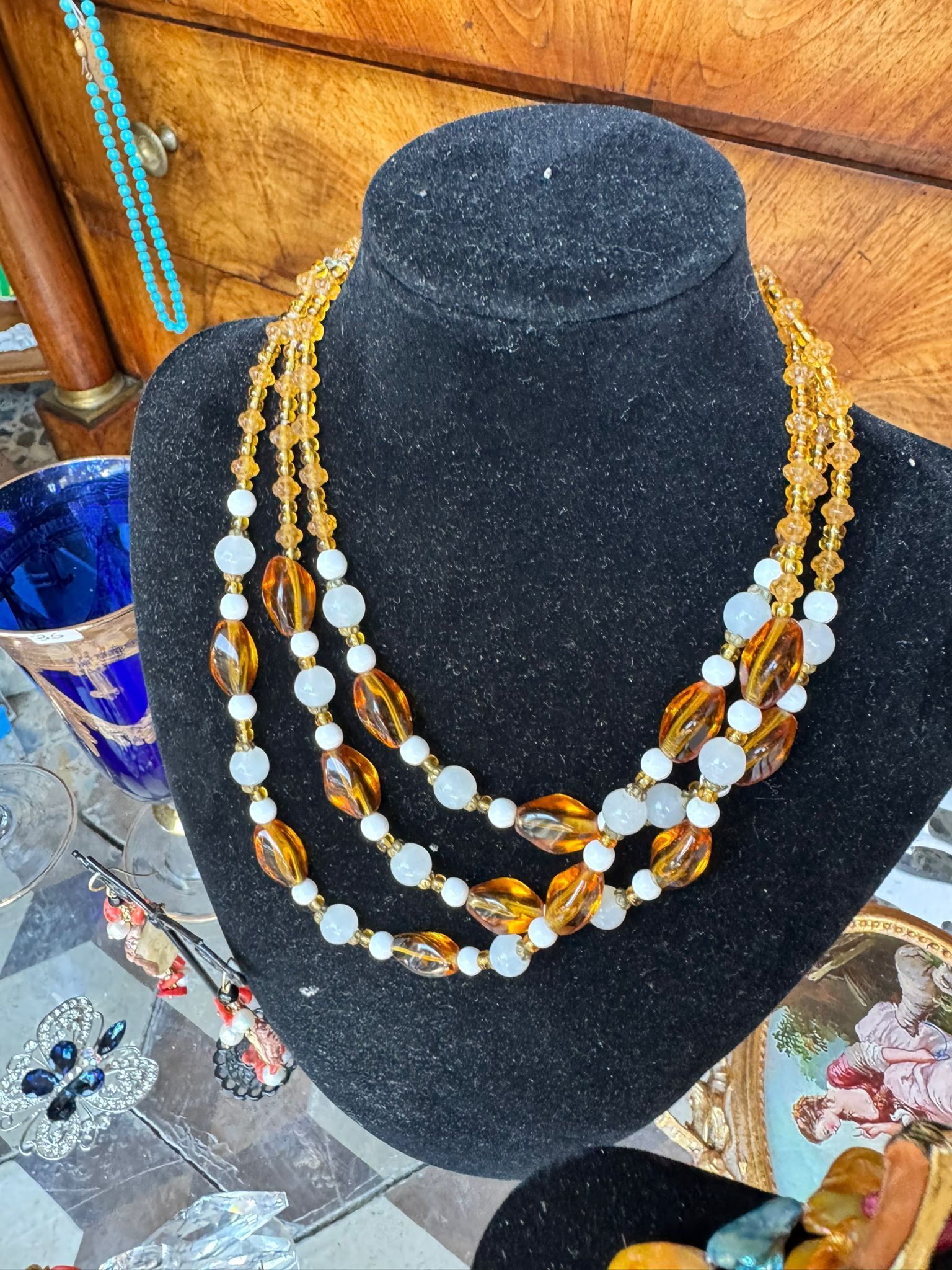Un manichino indossa una collana con tre fili di perline.