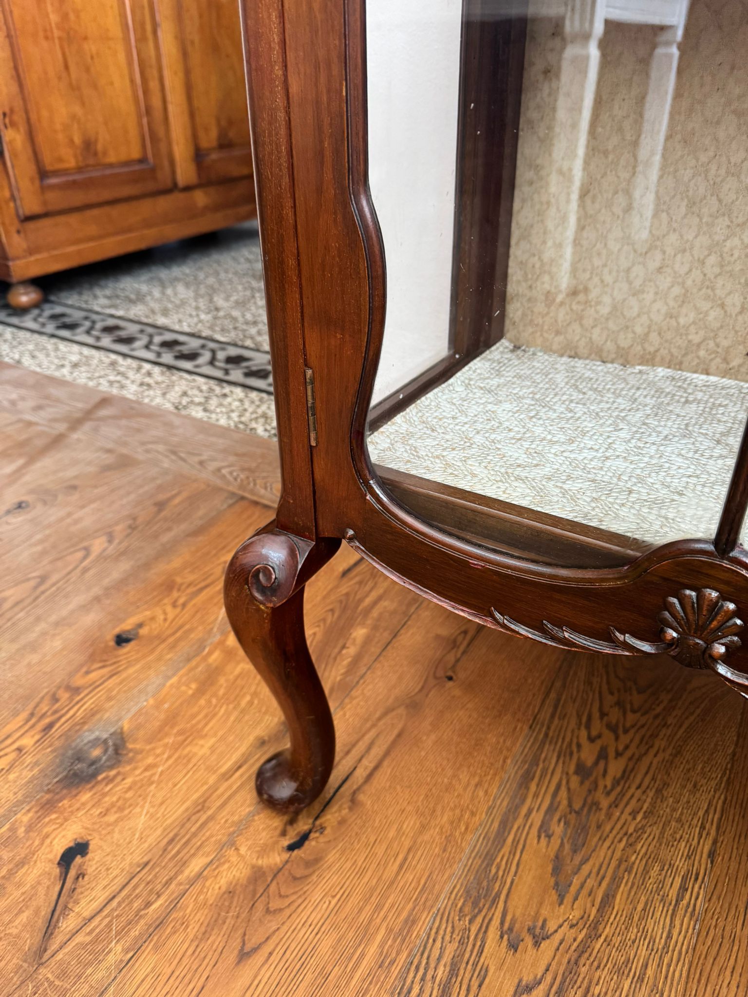 Primo piano di una vetrina di legno su un pavimento di legno.
