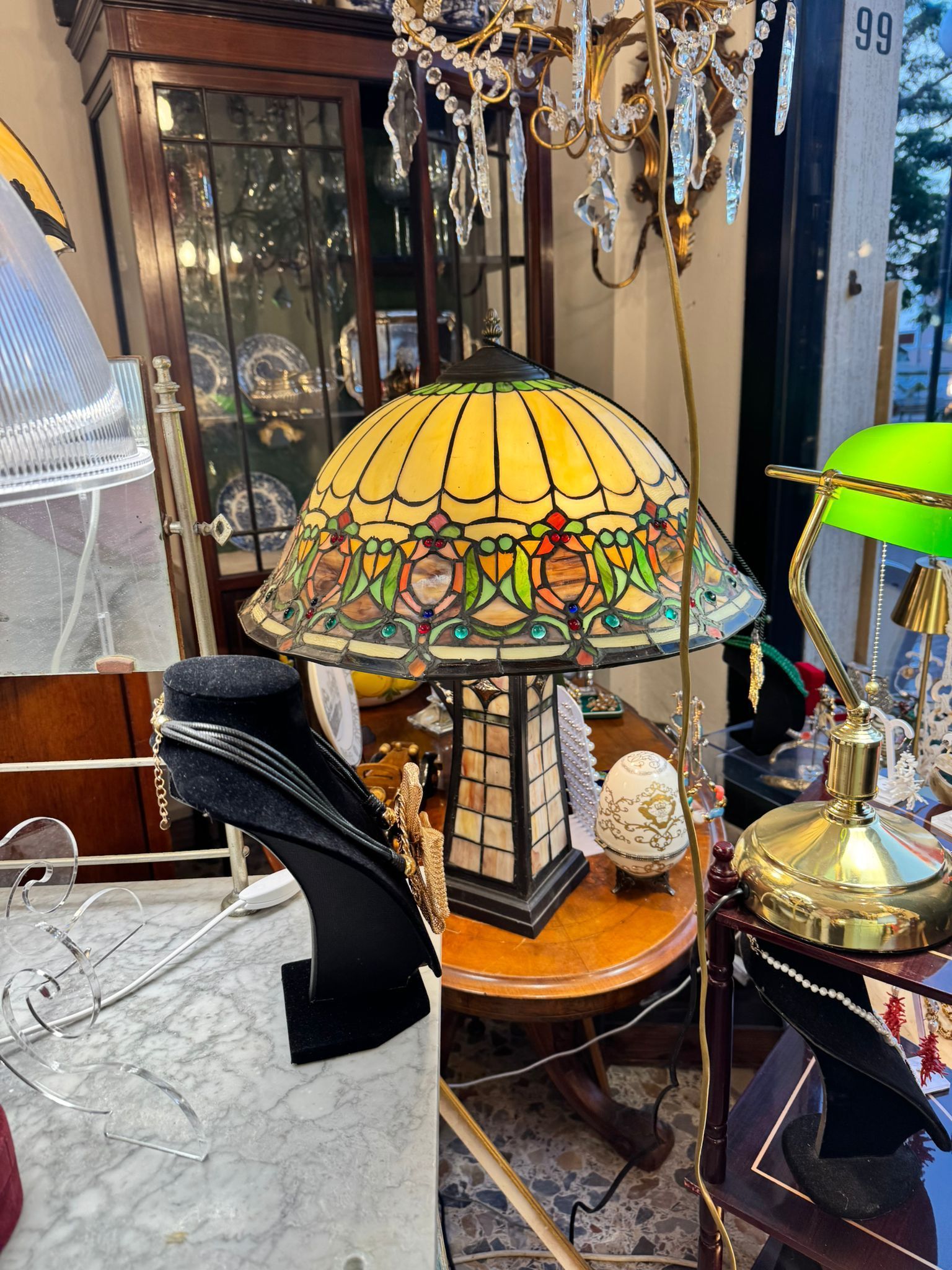 Una lampada in vetro colorato è appoggiata su un tavolo in una stanza.