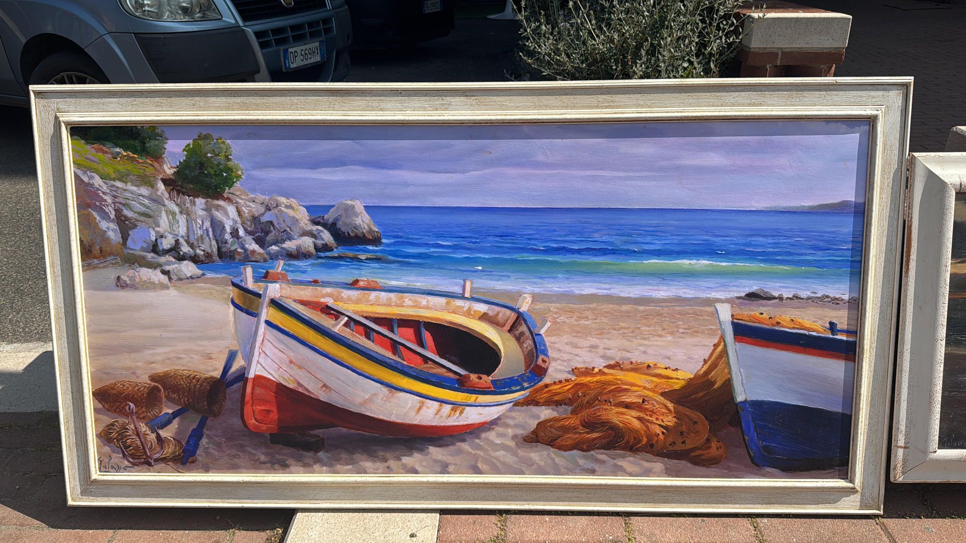 Un dipinto di due barche su una spiaggia incorniciate.