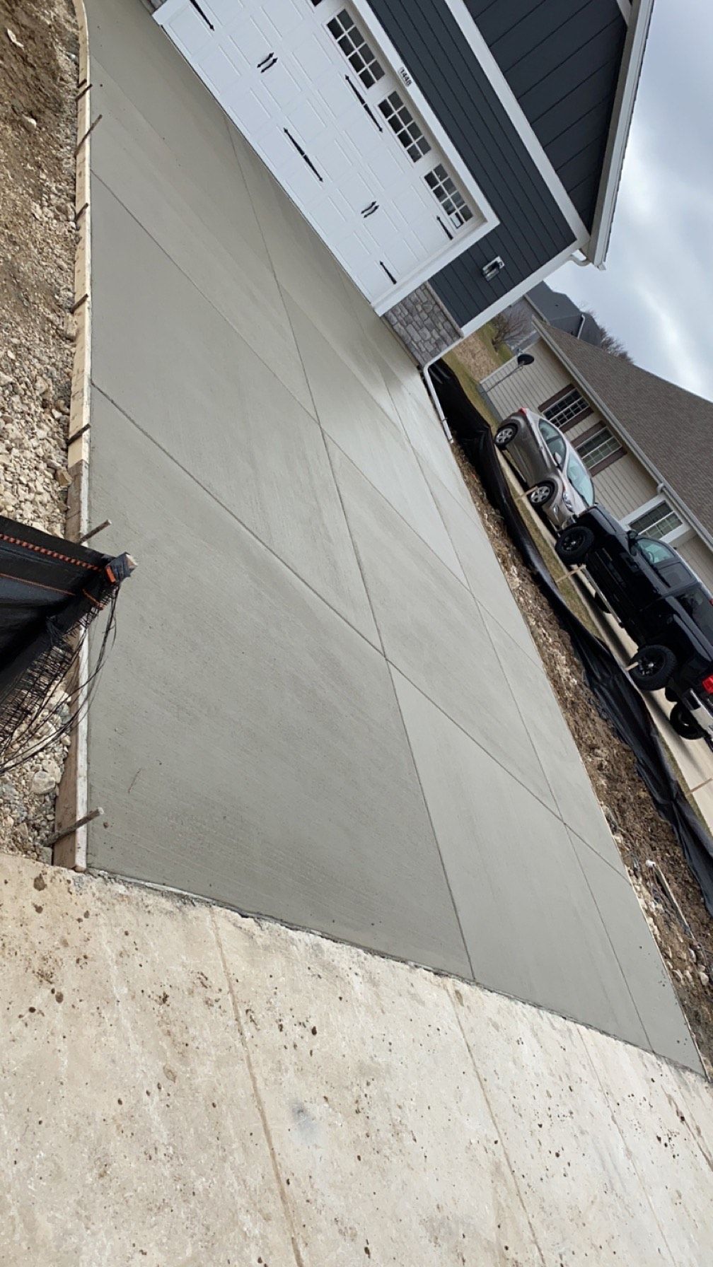 A concrete driveway is being built in front of a house.