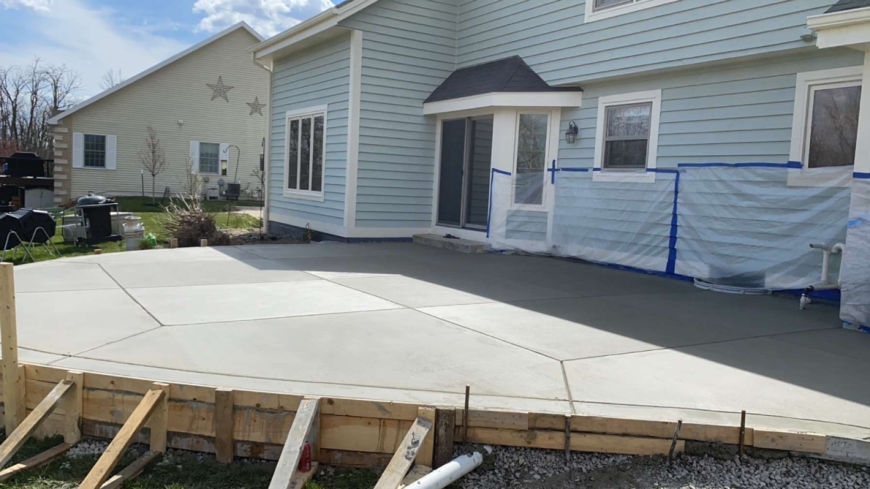 A concrete driveway is being built in front of a house.