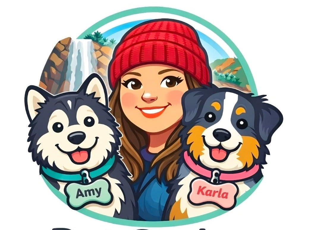 Woman in red beanie smiling between two dogs, with name tags Amy and Karla