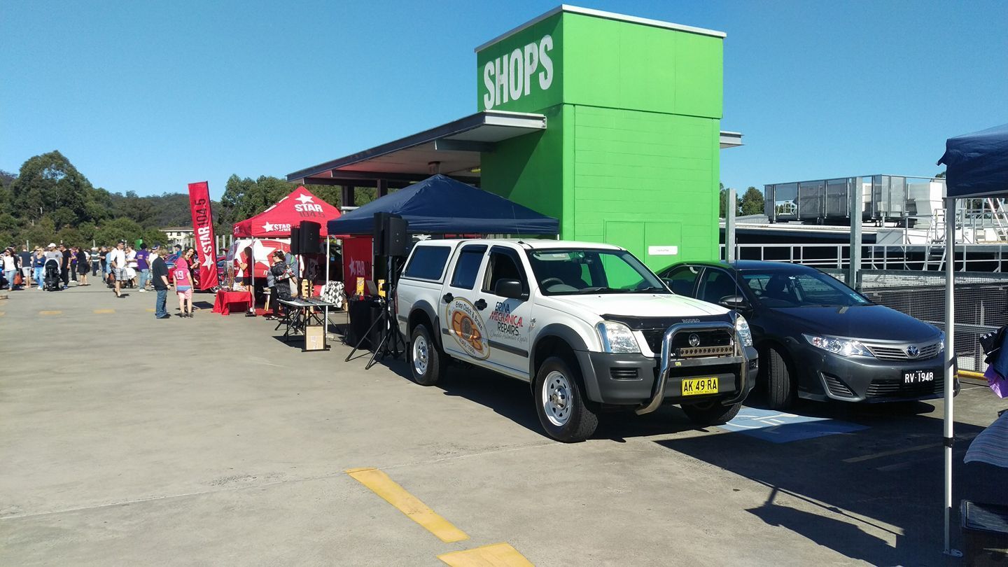White SUV Parked Near a Green Building — Erina Mechanical Repairs In Erina, NSW