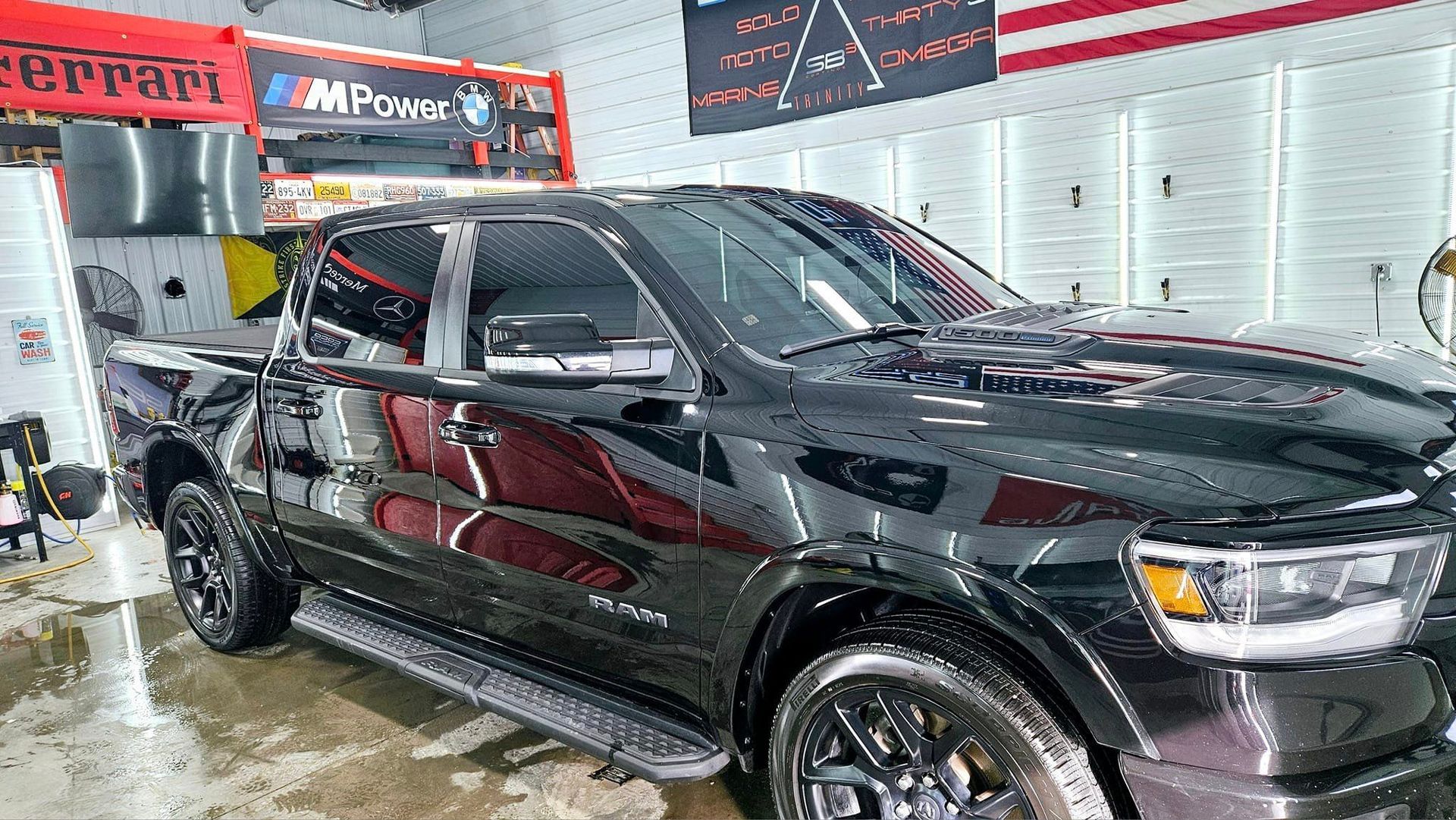 A black dodge ram truck is sitting in a car wash.