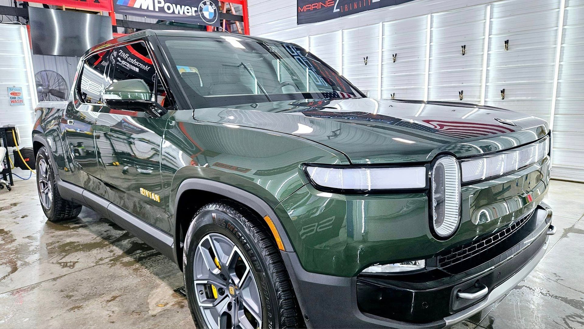 A green jeep is parked in a garage.