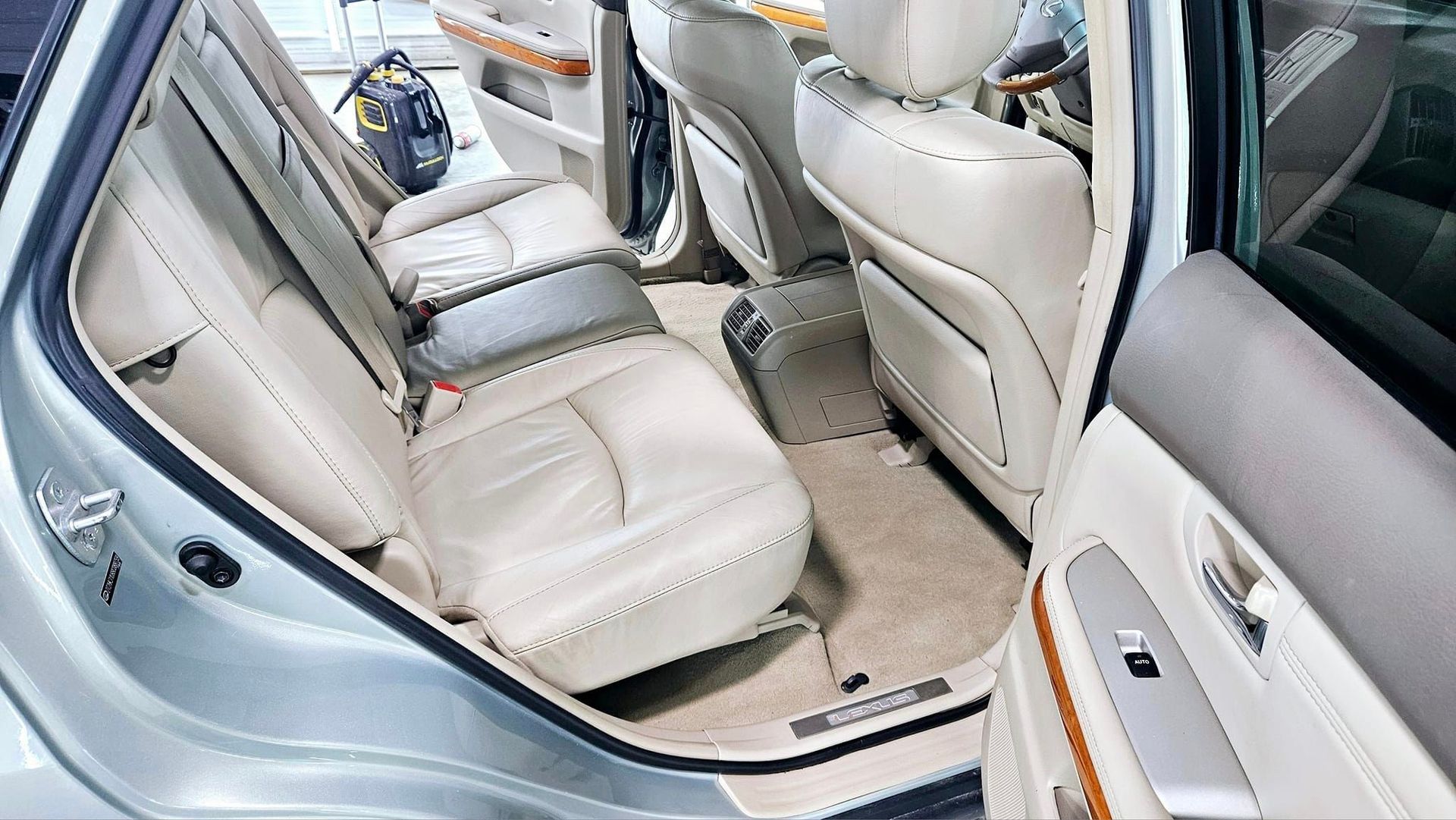 The back seat of a silver car with the door open