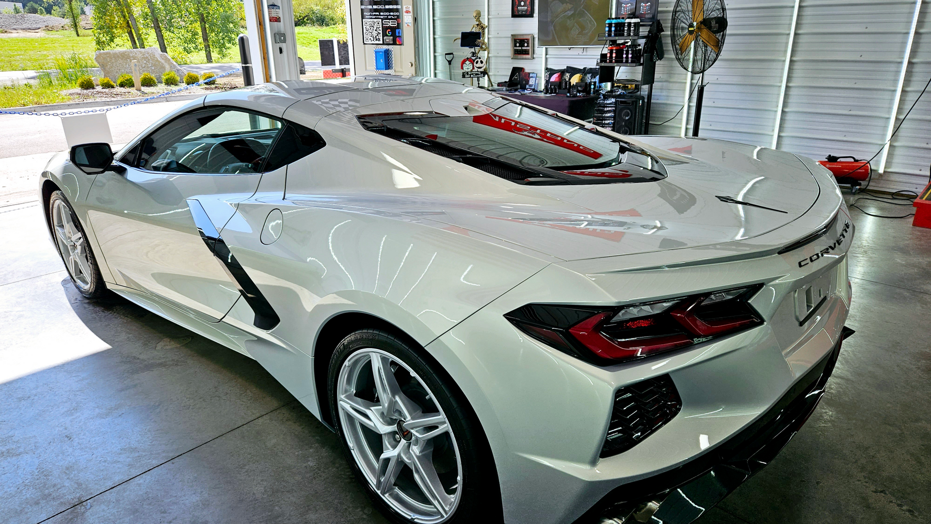 A white sports car is parked in a garage.