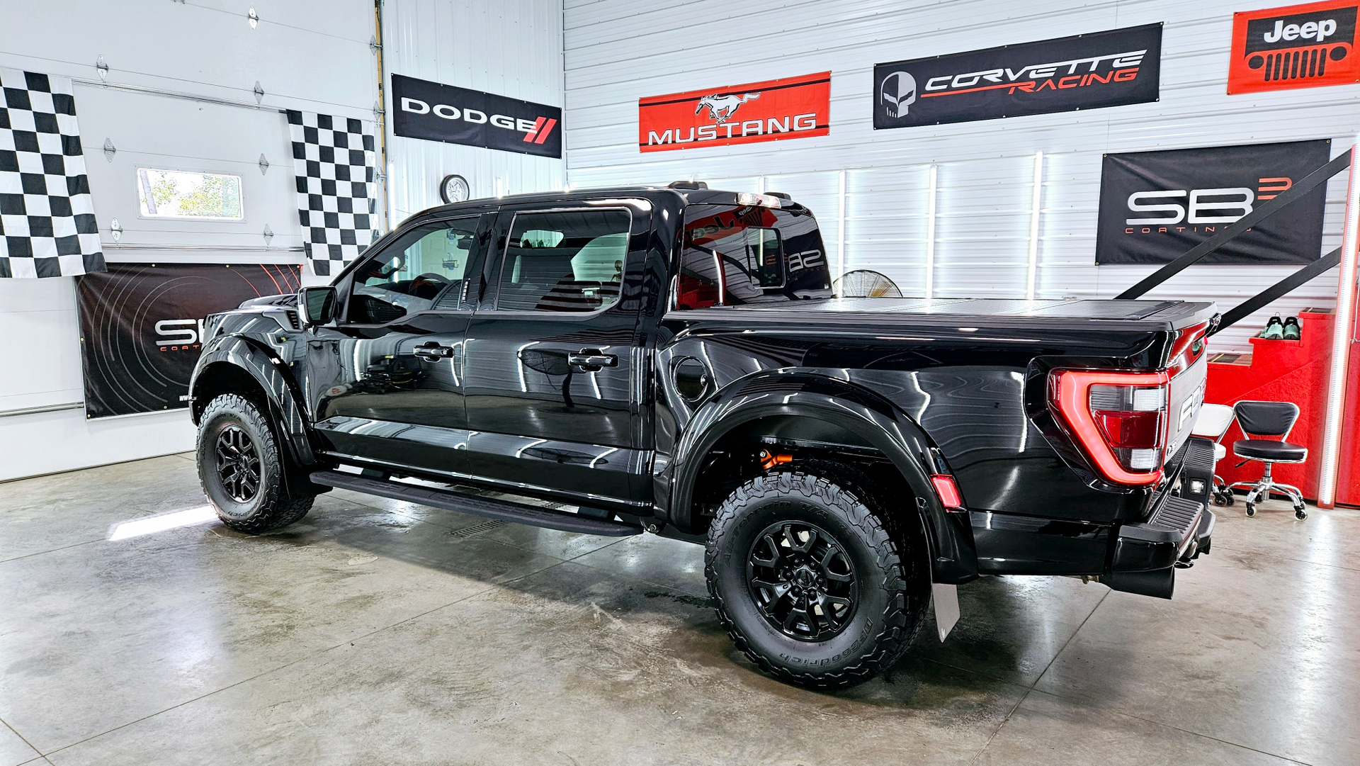 A black pickup truck is parked in a garage.