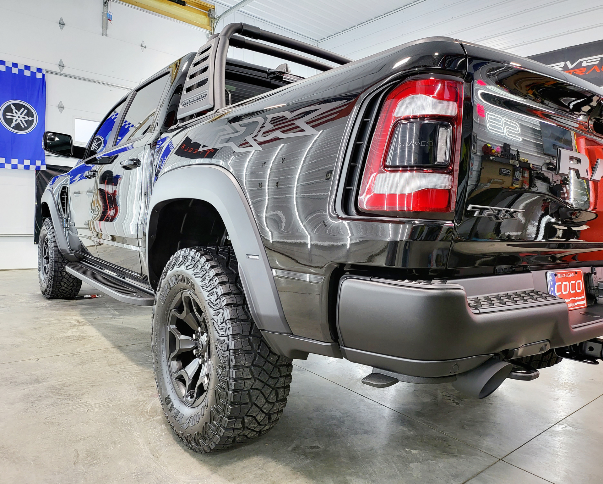 A black truck is parked in a garage.