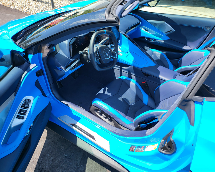 The inside of a blue sports car with the door open