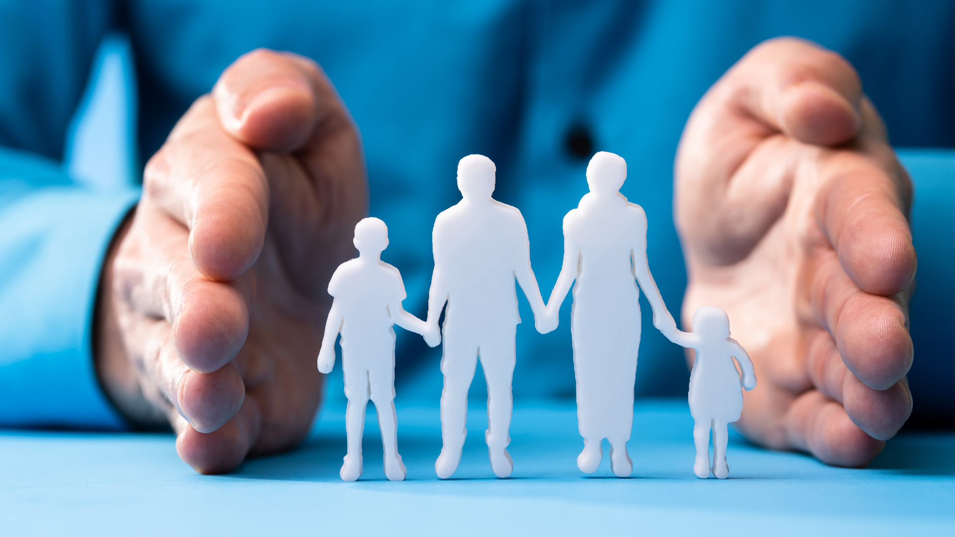 Hands cupping a white family silhouette, suggesting protection and security.