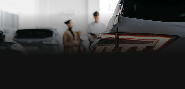 Blurred car showroom with two people and a framed item in the foreground