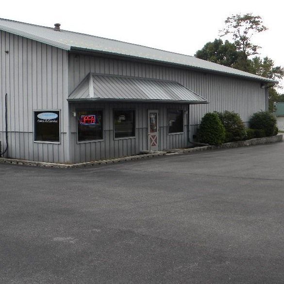 Exterior of a gray commercial building with a small awning. 