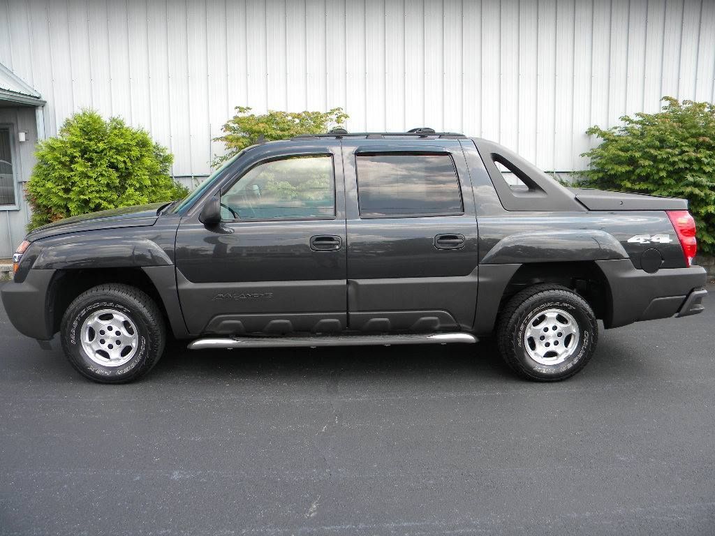 Dark gray Chevrolet Avalanche pickup truck parked outside on asphalt.