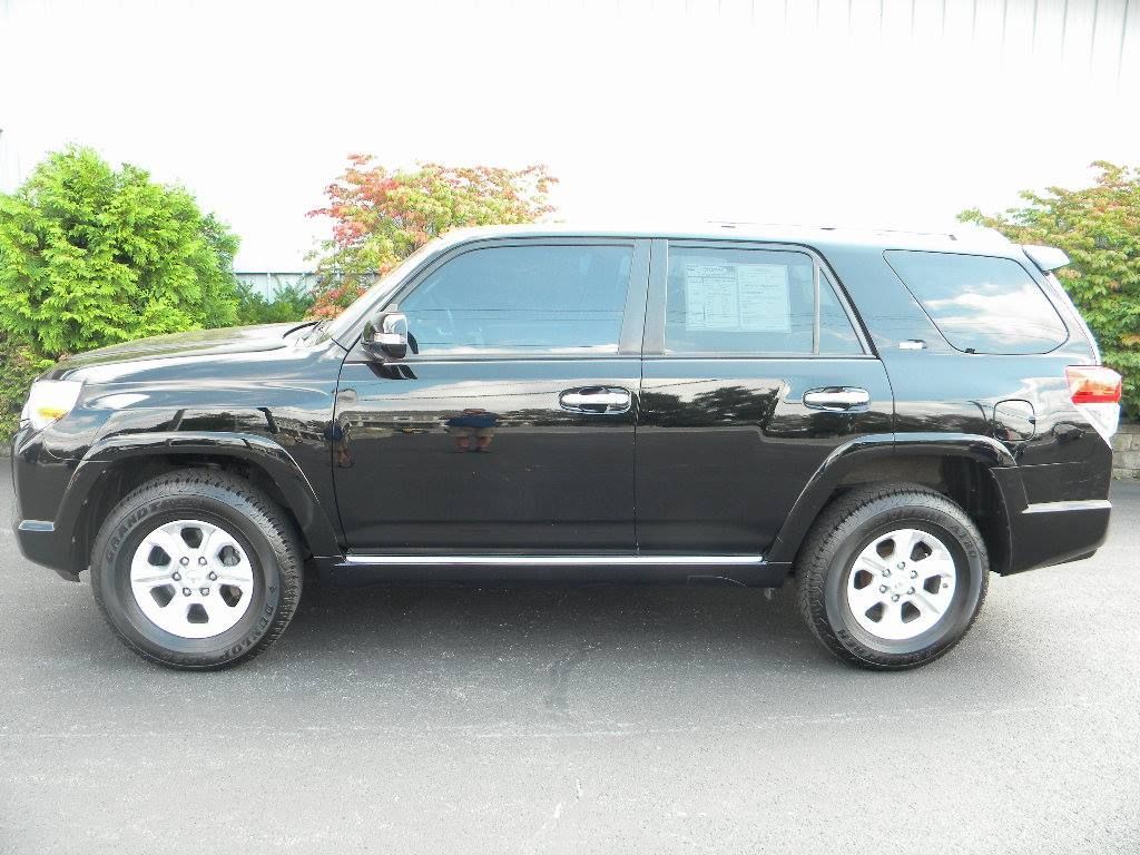 Black Toyota 4Runner SUV parked on pavement; tinted windows, silver trim, wheels.