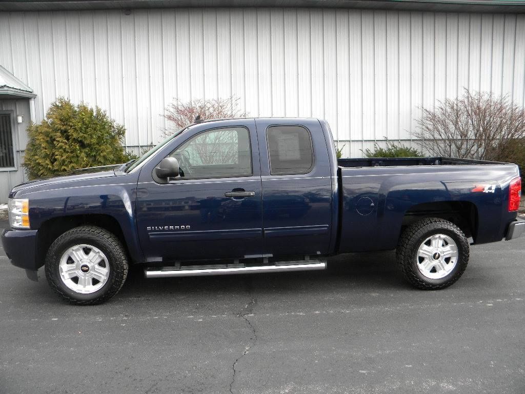 Blue Chevrolet Silverado pickup truck parked outside.