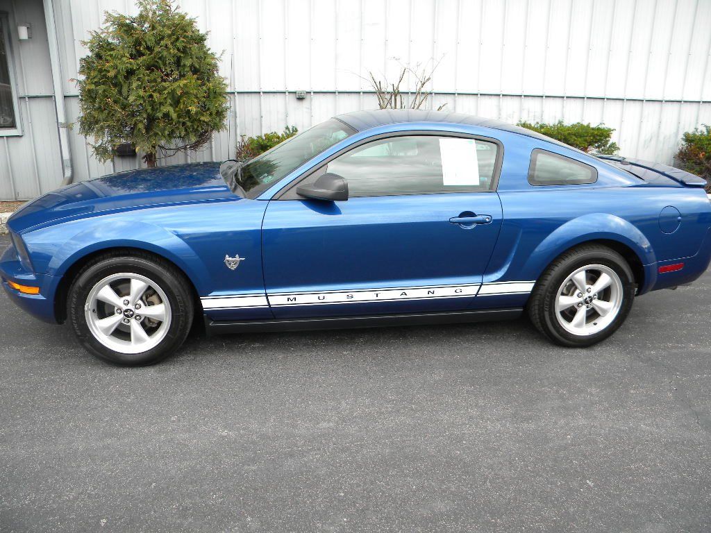 Blue Ford Mustang coupe parked on asphalt.