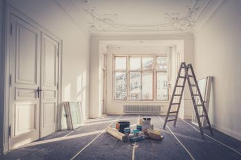 An empty room with a ladder and tools on the floor. An empty room with a ladder and tools on the floor.