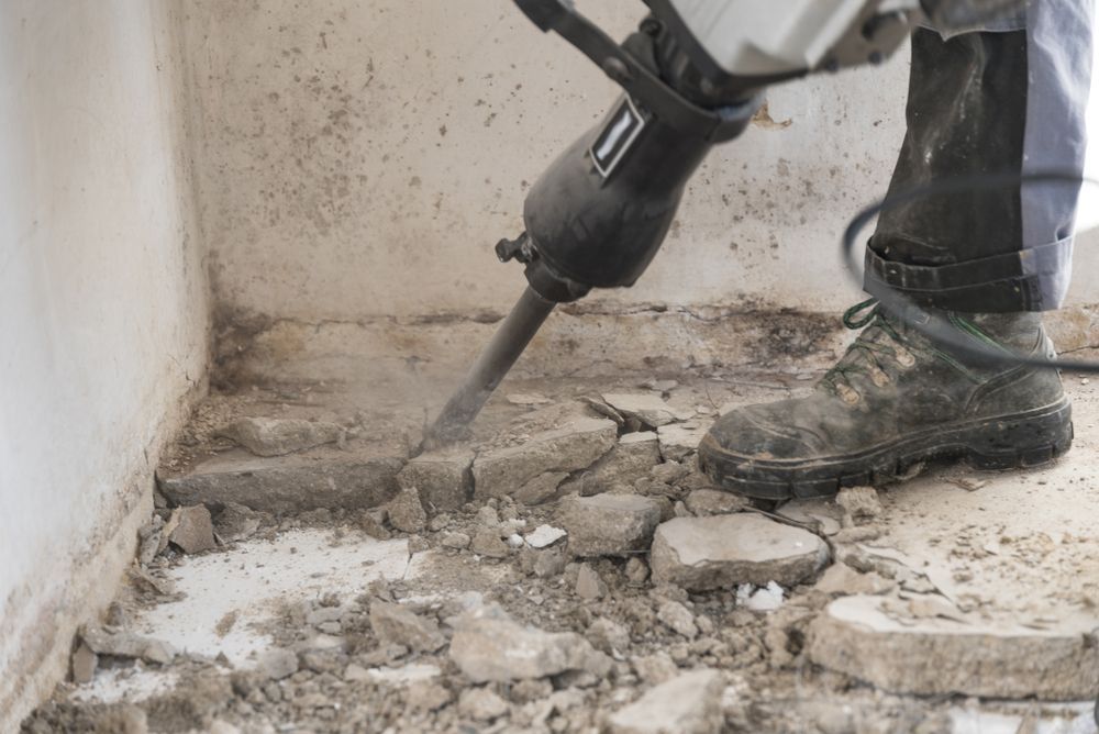 Person Using a Jackhammer to Break up Concrete Floor — C & S Building Pty Ltd In Evans Head, NSW