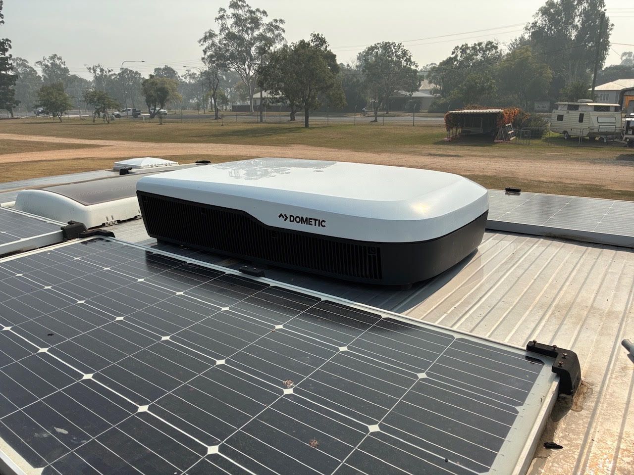 Damaged wall corner with flaking paint; brown tile floor; white boxes.