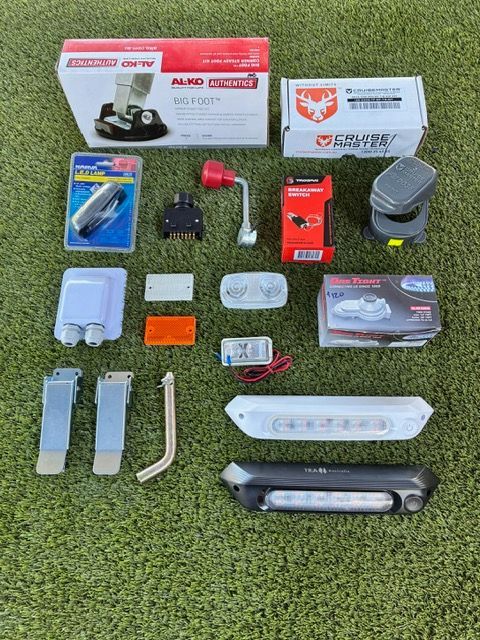 Various chassis components and accessories laid out on green grass.