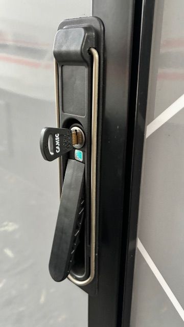 Black door lock with a key inserted, black handle, and silver trim.