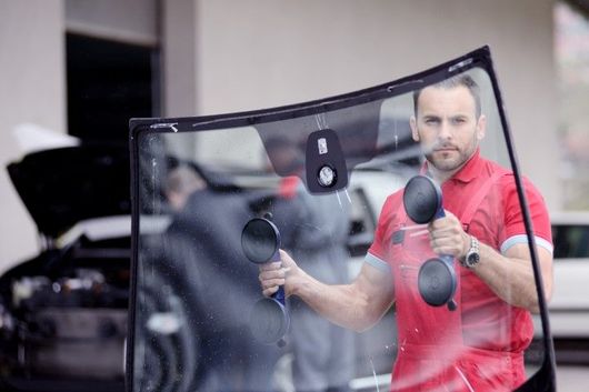 Windshield replacement specialist using suction tool in Titusville, FL