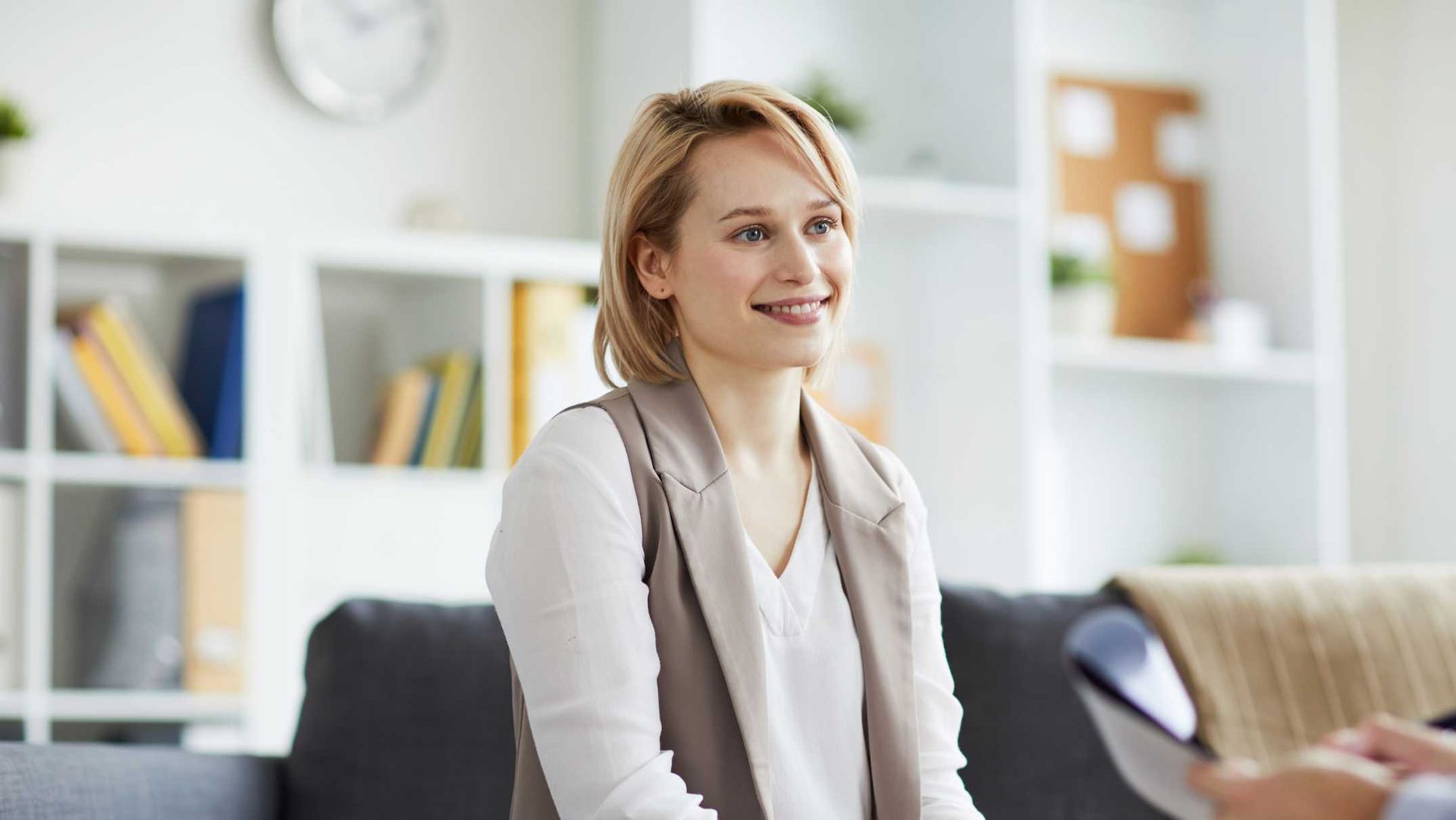 A woman is sitting on a couch talking to a man.