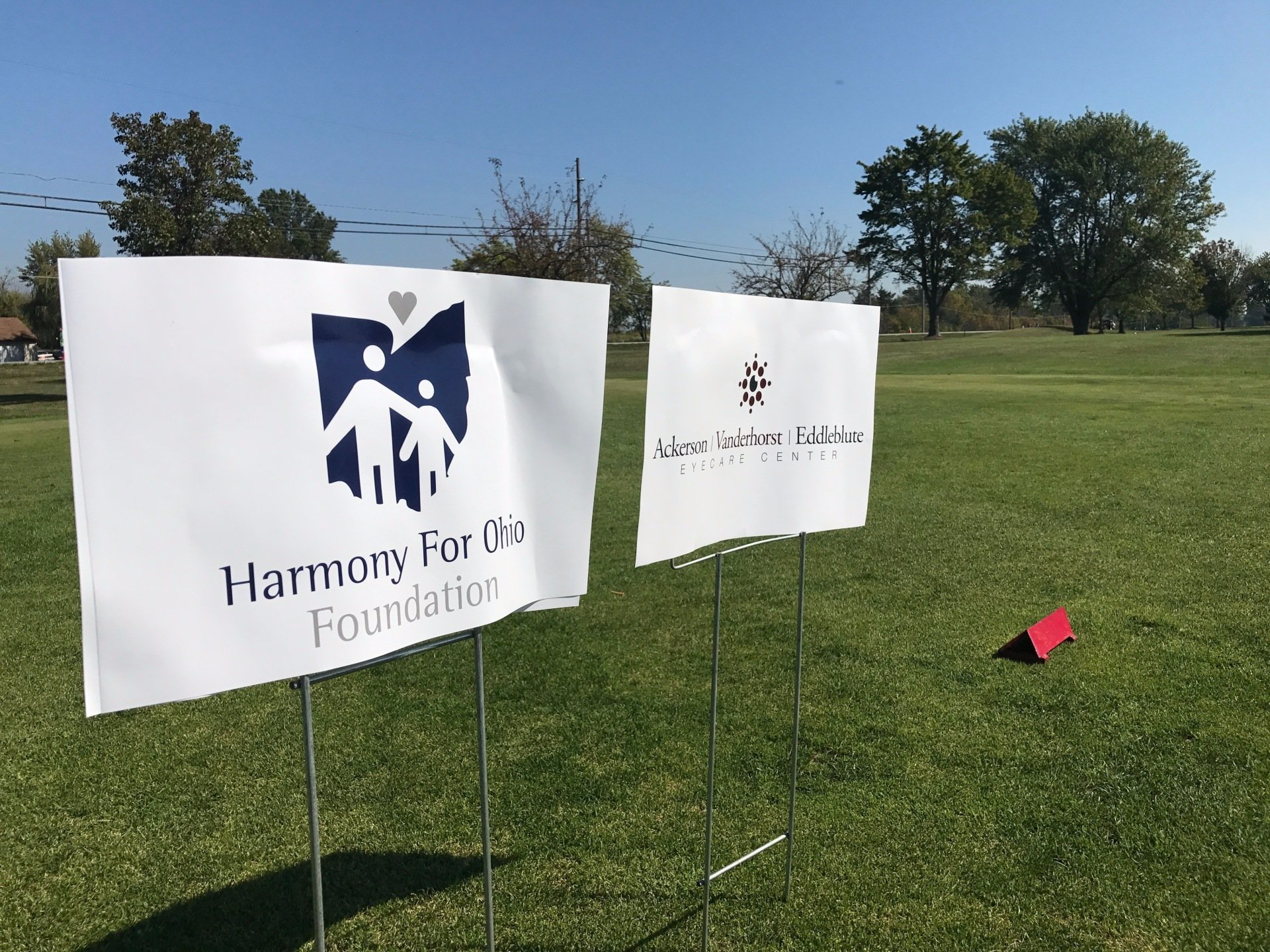 One Harmony for Ohio Foundation sign and one Ackerson, Vanderhorst, Eddleblute sign are on a tee box.