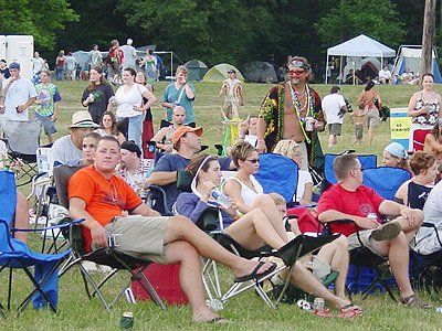 A group of people are sitting in chairs in a field