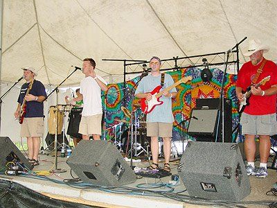 A group of men playing guitars and singing on a stage