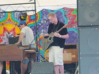 A man playing a guitar and singing into a microphone