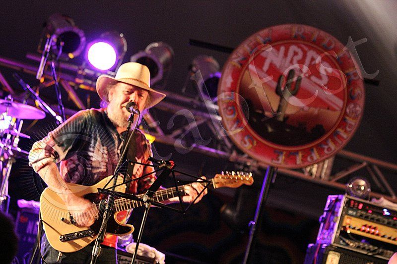 A man in a cowboy hat is playing a guitar and singing into a microphone. This man is David Nelson and his band is the New Riders of the Purple Sage. They performed at Tabfest.
