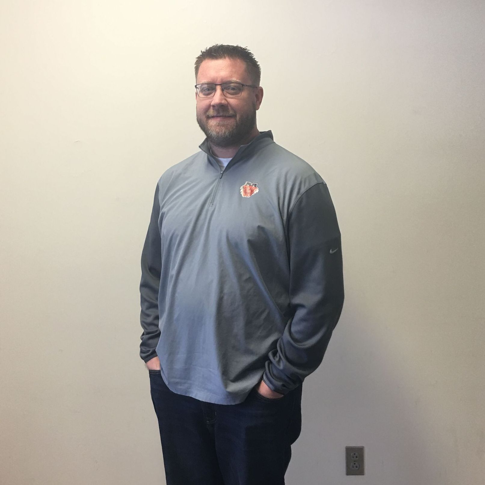 A man with a beard wearing a gray shirt with a u.s. flag on it