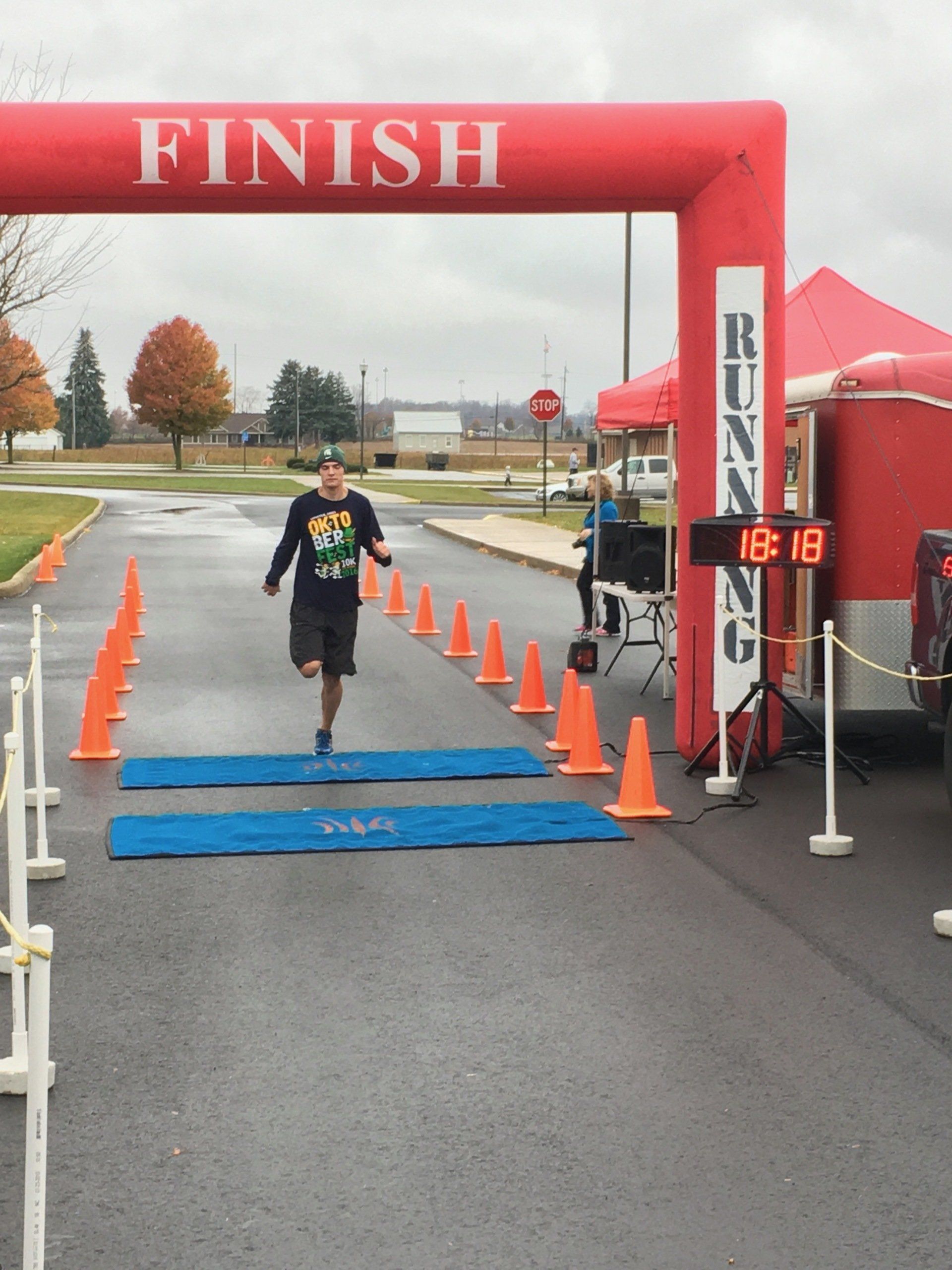 A man is running under a red finish line banner