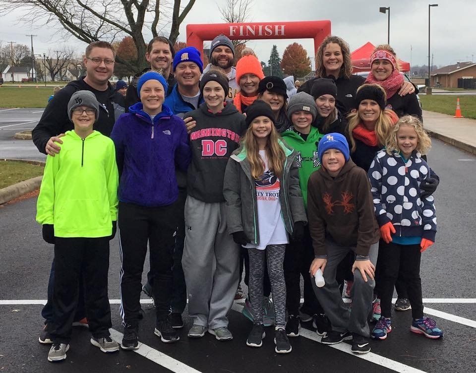 A group of people standing in front of a red finish line banner