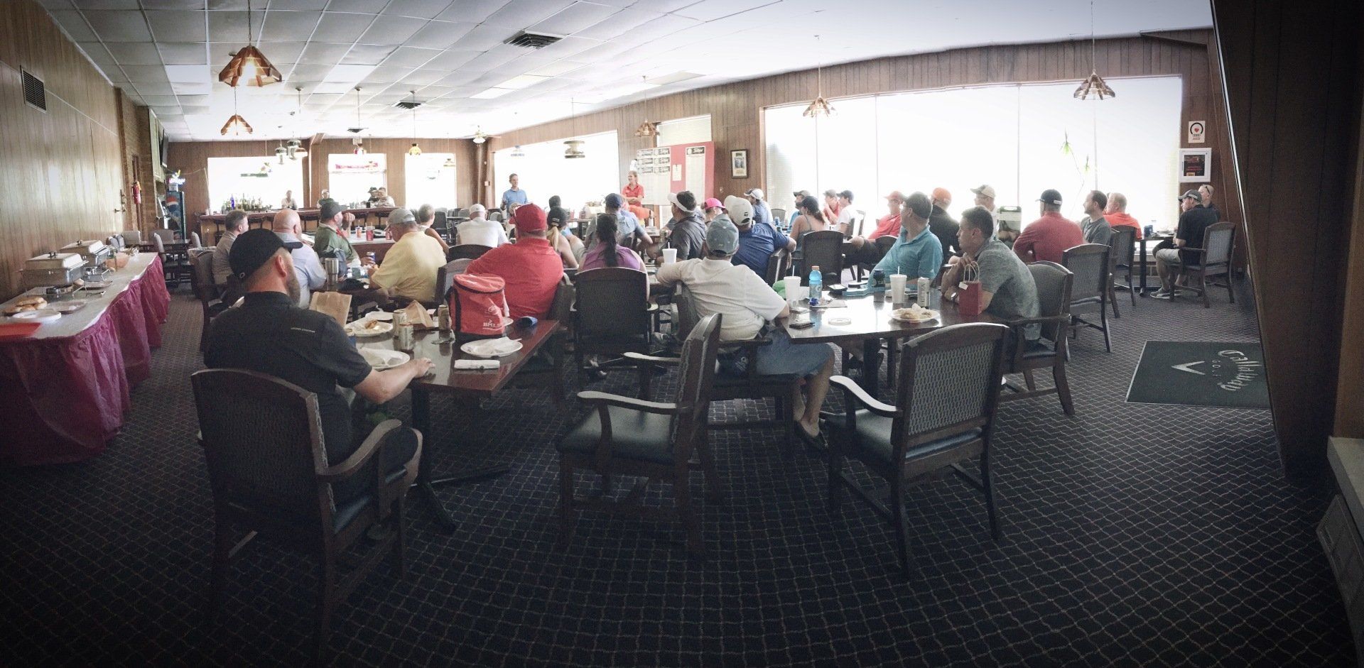 A large room filled with people sitting at tables