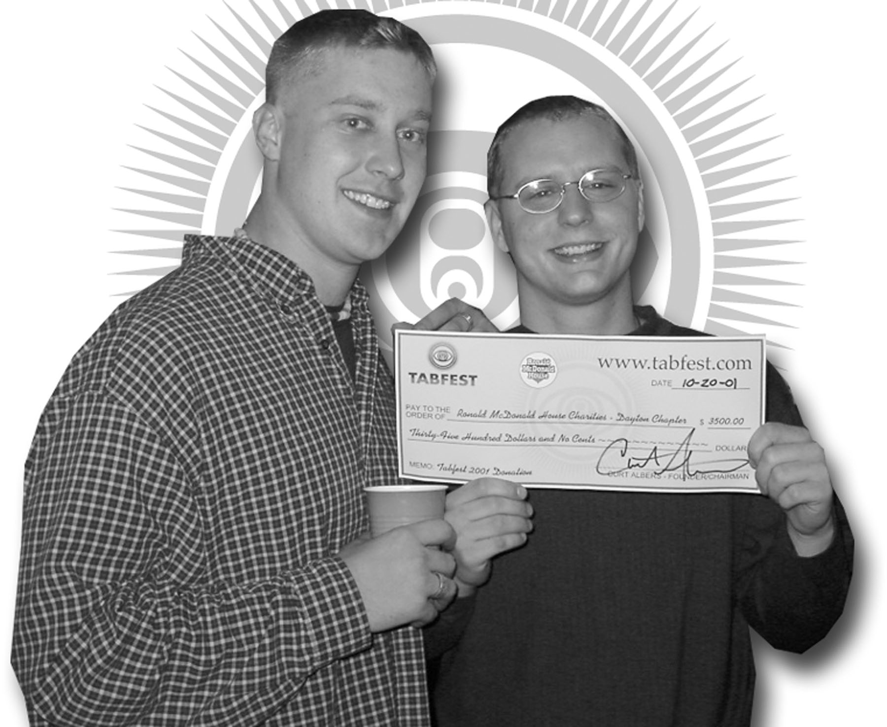 Two men are holding a check