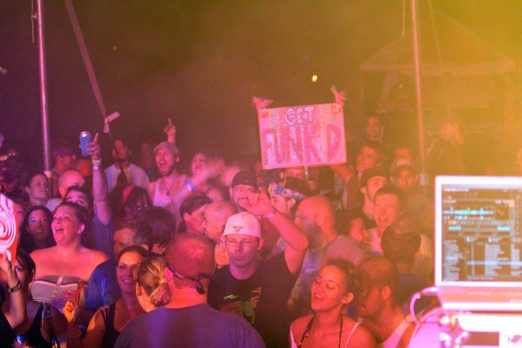 A crowd of people are standing in a dark room holding signs.